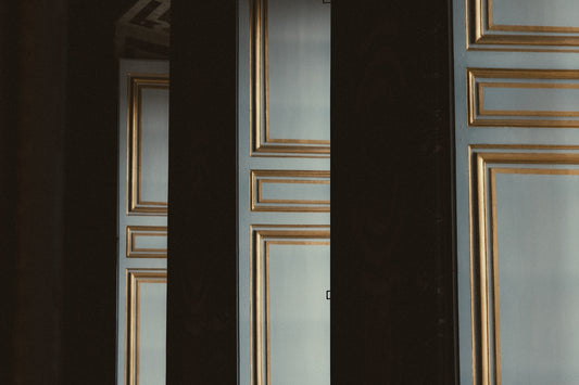 Elegant doors with gold trim are partially obscured.