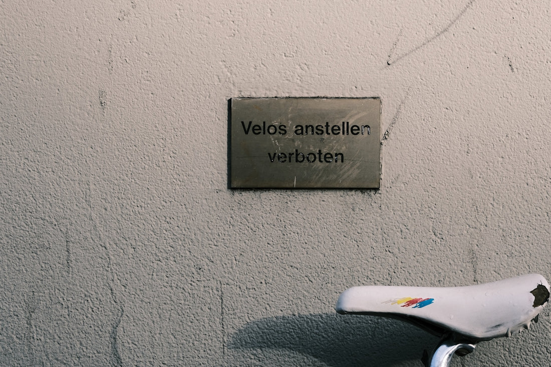 a bicycle parked next to a wall with a sign on it