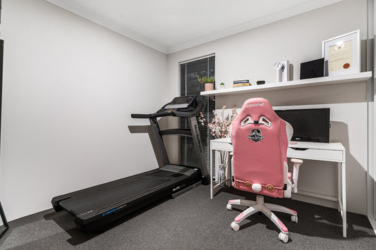 A room with a treadmill and a desk