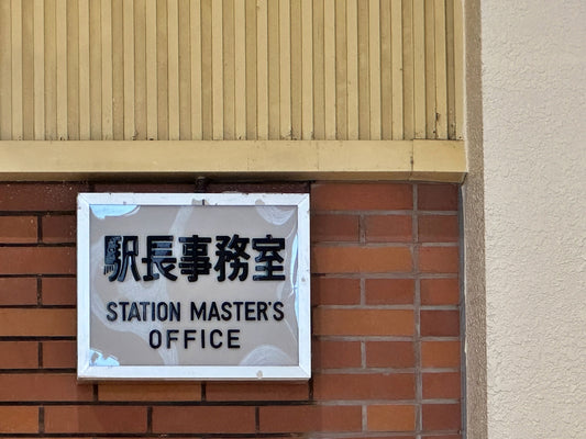 A sign on the side of a building that says station master's office