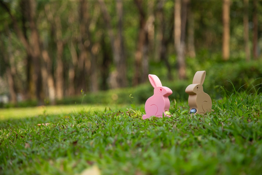 Two cardboard bunnies sit in the grass.