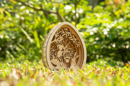 A wooden egg art piece sits on green grass.