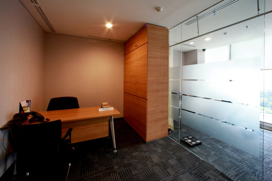 An empty office with a desk and a glass wall.